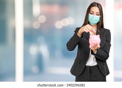 Masked Businesswoman Putting Money In A Piggy Bank, Coronavirus Savings And Investments Concept