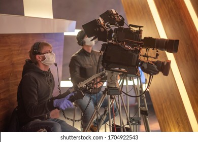 masked cameraman is filming a television show in the studio. TV