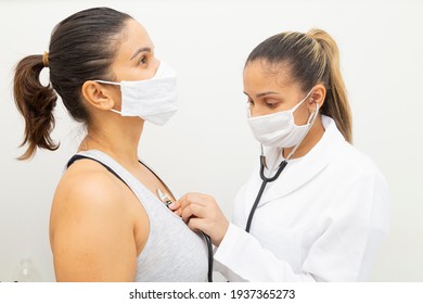 Masked Doctor Listening To The Heart Of A Patient Who Is Wearing A Mask.