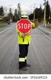 Masked Female Flagger Or Traffic Control Person At Work Contolling Traffic