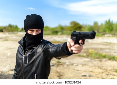 Masked Gunman Taking Aim With A Gun