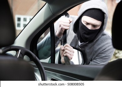 Masked Man Breaking Into Car With Crowbar