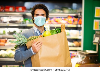 Masked Man Holding An Healthy Food Bag In A Supermarket During The Coronavirus Pandemic