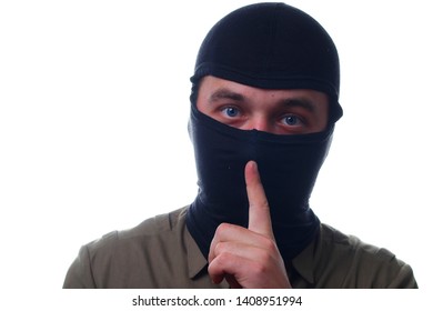 A masked man holds his index finger in his mouth. The concept of silence, secrecy on white background