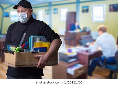 The masked man leaves the workplace. Dismissal from work. Job loss. Reduction of the company's staff. Unemployment. The shock of losing your job. An increase in the number of unemployed. - Shutterstock ID 1716111766