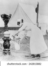 Masked Nurse Pumping Water At A Field Hospital During The 1918 Spanish Flu Pandemic. Photographed In United States, September 1918.