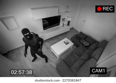 MASKED ROBBER IN BALACLAVA STEALING IN A HOUSE CAPTURED ON SURVEILLANCE CAMERA. BURGLAR ALARM SYSTEM FOR SECURITY AND PROTECTION. HOME THEFT INSURANCE.