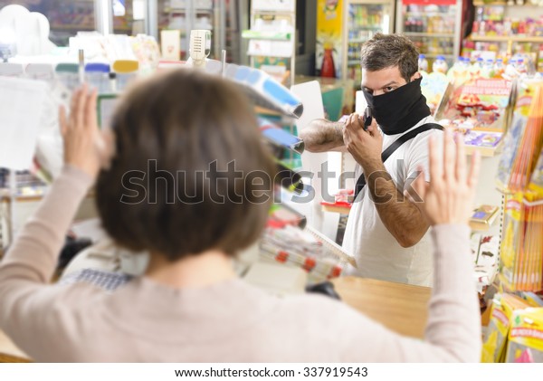 Masked\
thief pointing a gun to sales woman in a\
store