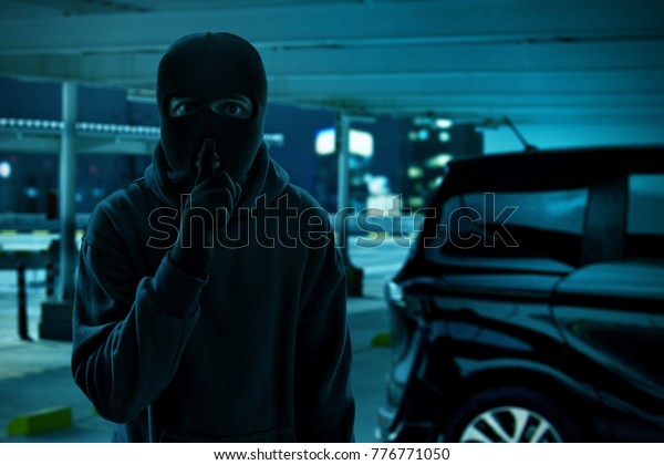 Masked thief trying to steal\
a car