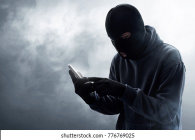 Masked Thief Using Mobile Phone