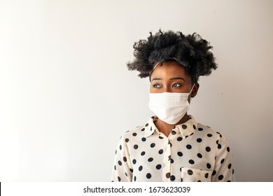 Masked woman - protection against influenza virus. African - American woman wearing mask for protect. Woman wear with protective face mask at home. Stop the virus and epidemic diseases. - Shutterstock ID 1673623039