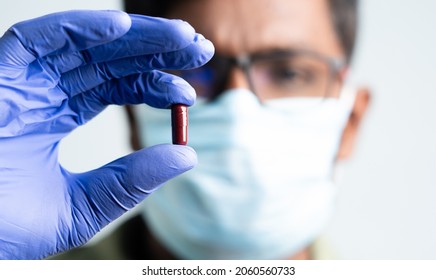 Maski, India - October,16, 2022 : Selective Focus On Pill, Close Up Of Doctor Holding Molnupiravir Antiviral Drug Against Coronavirus Covid 19 Outbreak