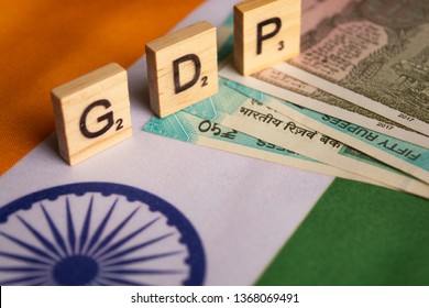 Maski,India 13,April 2019 : GDP Or Gross Domestic Product In Wooden Block Letters On Indian Flag With Indian Currency.