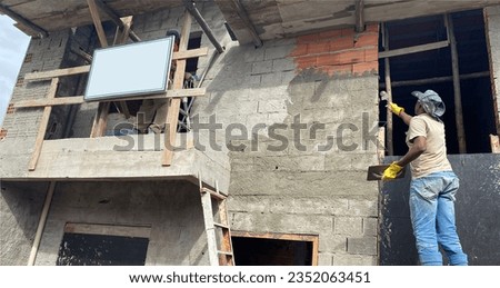 mason and helpers roughcasting and plastering the facade of the house, on top of wooden scaffolding