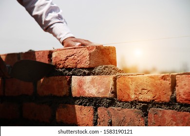 Mason installing brick on construction site for making house.     