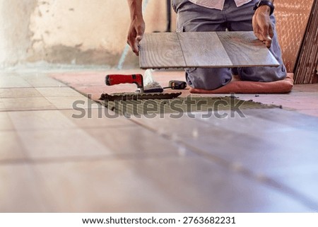 A mason installing a ceramic floor