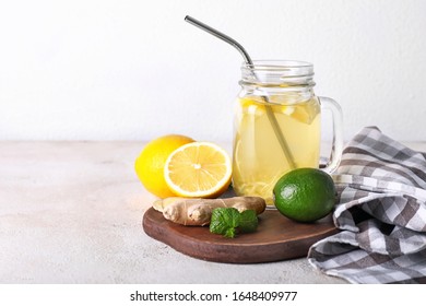 Mason Jar Of Healthy Drink With Citrus Fruits And Ginger On White Background