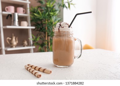 Mason Jar Of Tasty Frappe Coffee On White Table