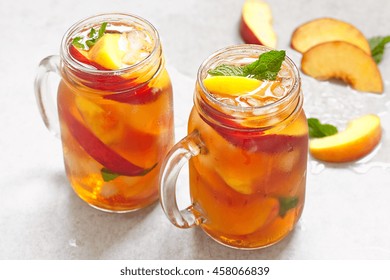 Mason jars of peach tea with ice