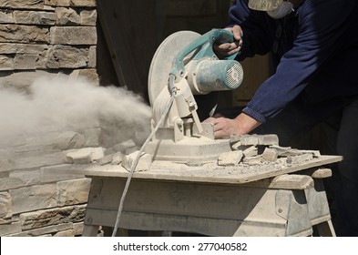 Masonry Contractor Using A Dry Circular Tile Or Rock Cutting Saw To Trim Rock Siding For A Home Installation