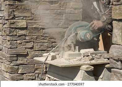 Masonry Contractor Using A Dry Circular Tile Or Rock Cutting Saw To Trim Rock Siding For A Home Installation