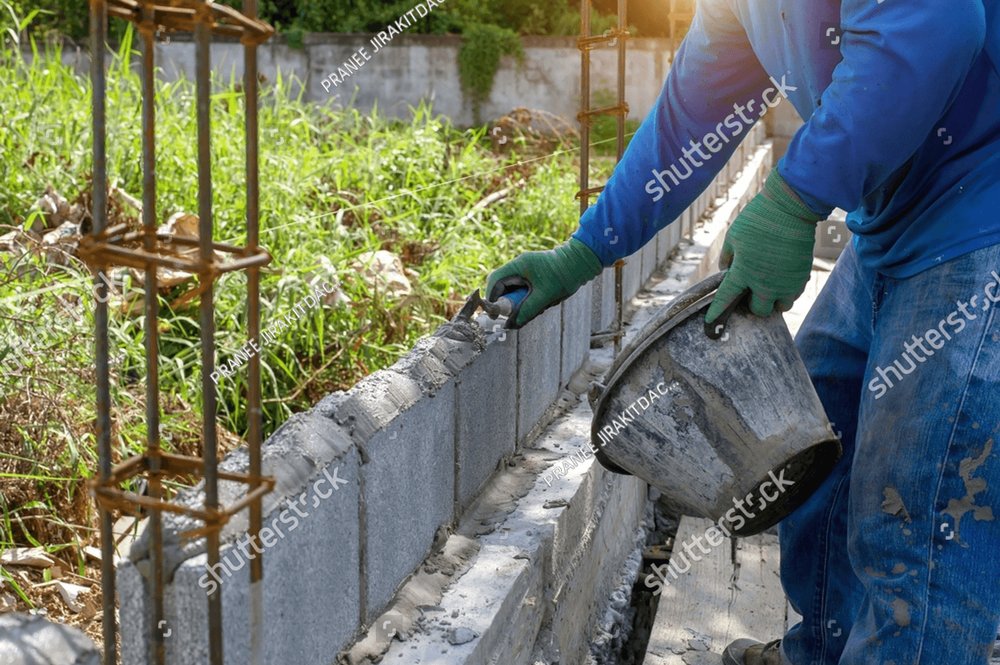 masonry worker make concrete wall by cement block and plaster at ...