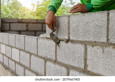masonry worker make concrete wall by cement block and plaster at construction site - Shutterstock ID 2079667405