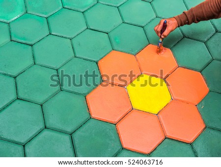 masonry worker painting paving block by color   and hand brush