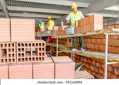 Masons, Bricklayer Workers Are Building Dividing Indoor Wall At The Construction Site. 