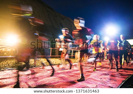 mass start runners outdoors with flashlights in the dark. Blur