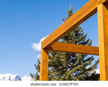 Mass Timber Beam Construction With A Pine Tree In The Background And A Snow Covered Mountain Peak In The Distance