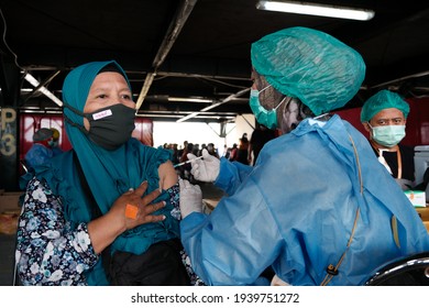 Mass vaccination in Yogyakarta, Indonesia March, 20th 2021. Doctors getting vaccine injected in a public parking lot area Malioboro, Yogyakarta. Medical workers giving people Covid-19 antidote.