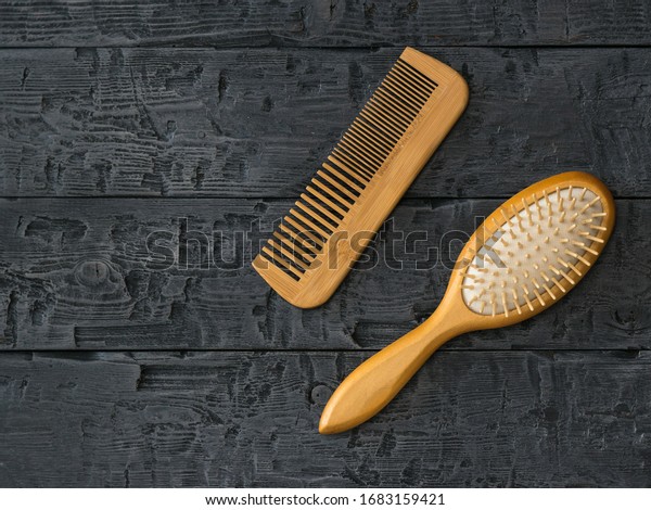 Massage comb and comb comb on a wooden table.\
Device for combing\
hair.