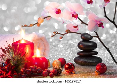 massage composition christmas spa with candles, orchids and black stones