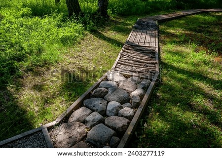 Massage path with different textures, flatfoot prevention, natural tactile sensory path, stones, logs, fir cones. Health path in nature.