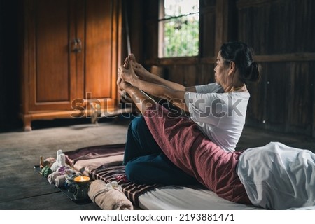 Massage and spa relaxing treatment of office syndrome traditional thai massage style. Asain senior female masseuse doing massage treat hand, back pain, arm pain, foot and stress for old woman tired.