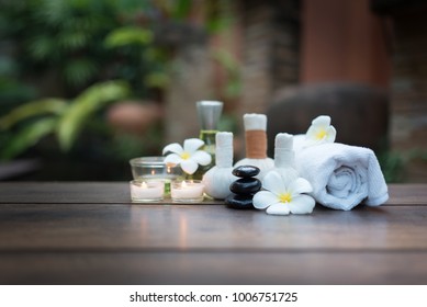 Massage stones and spa composition candles on the old wooden