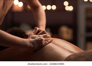 Massage therapist applying light touches when massaging back of client - Powered by Shutterstock