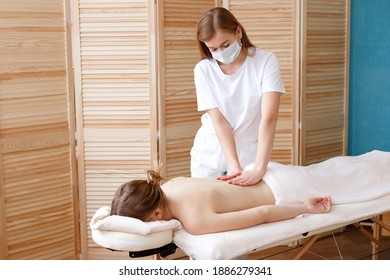 Massage Therapist In A Mask Does A Massage