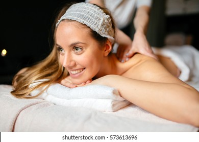 Massage therapist massaging beautiful brunette