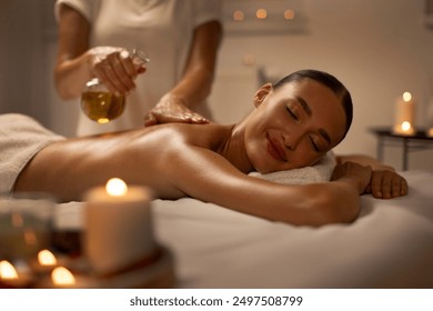 Massage therapist pouring oil on lady back during spa session, aromatherapy and healing massage procedures, focus on relaxed woman - Powered by Shutterstock