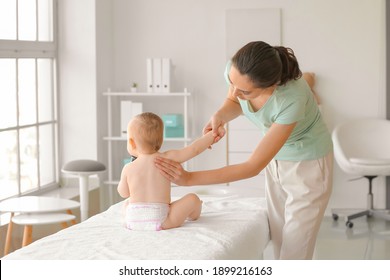 Massage therapist working with cute baby in medical center - Powered by Shutterstock