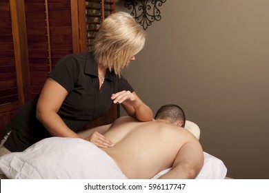 Massage Therapy Theme Photo. Female Massage Therapist Massaging A Male Client.