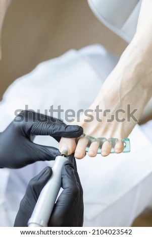 massage and treatment of legs and feet at a podiatrist doctor with a magnifying glass, scraper, scissors, sanding, file, medicine, fingers, manicure, pedicure