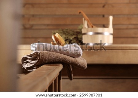 Massaging brush, stack of towels and other supplies in sauna, selective focus