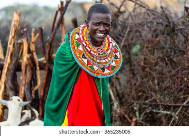 Massai woman standing in her village while it rains
