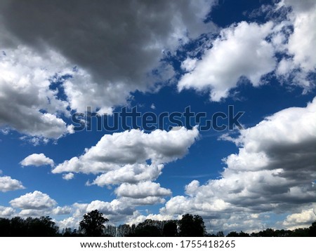 Masses of fluffy white clouds against a deep blue sky