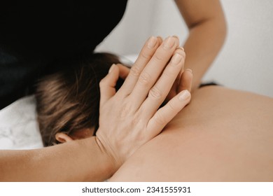 Masseur doing a foot massage with candles on background - Powered by Shutterstock