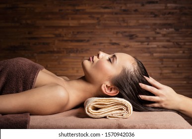 Masseur Doing Massage The Head And Hair For An Woman In Spa Salon