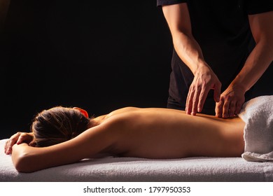 Masseur Hands Doing Back Massage To Client In Spa Center In Dark Room